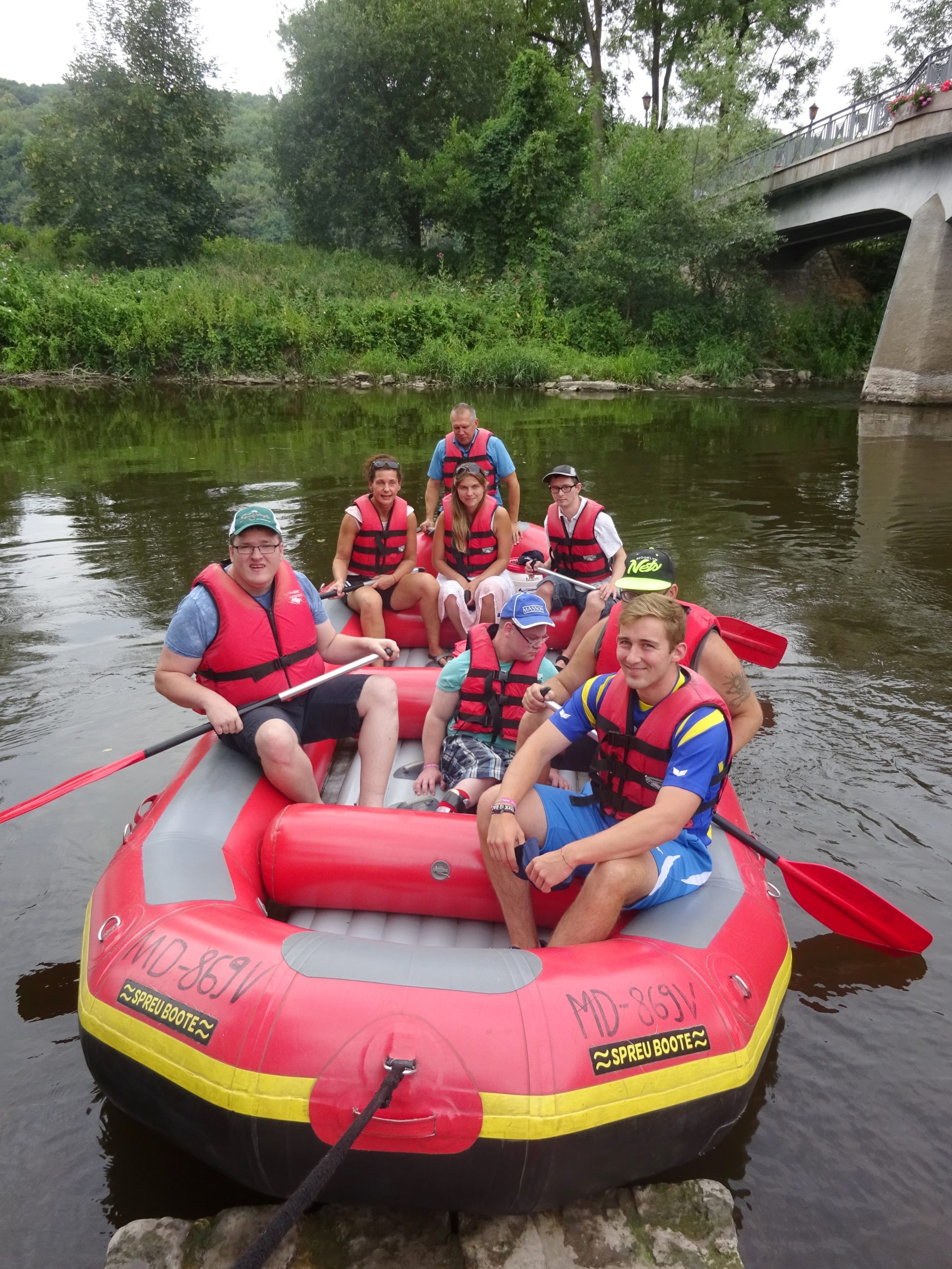 Mehrere Personen sitzen im Schlauchboot und schauen in die Kamera.