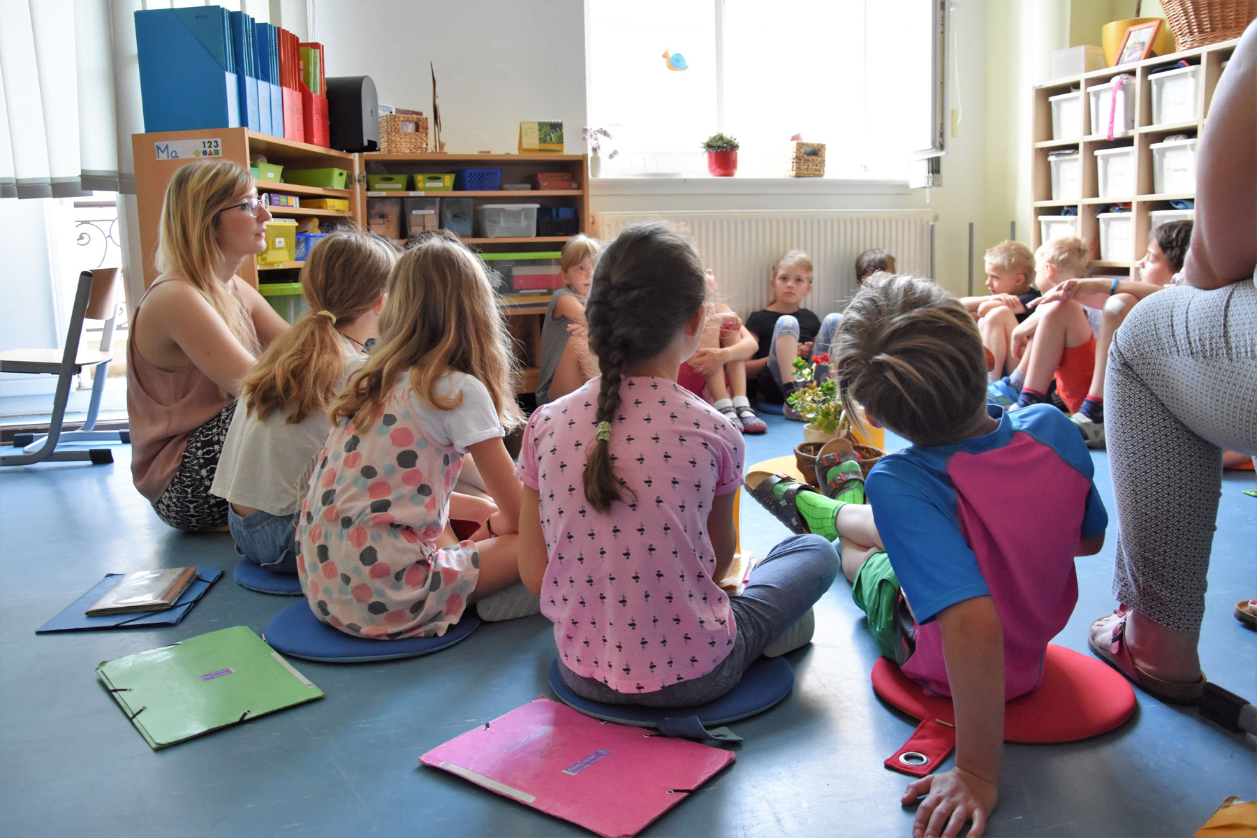 Lehrerin mit Schüler*innen im Morgenkreis
